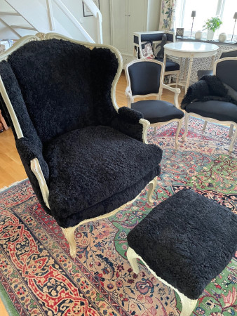 Fåtölj och pall omklädda i fårskinn Black.